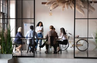 Diverse,Businesspeople,Negotiating,At,Group,Meeting,Led,By,African,Woman